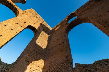 İmparatorluk Villa dei Quintili 'nin etkileyici mimarisi, kalidaryumun mimari ayrıntıları, termal banyolar, güzel bir ekim gününde harabeler Appia Antica Roma' nın mavi gökyüzüne karşı duruyor..