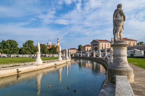 プラート デッラ ヴァレの2列の彫像とイタリアのパドヴァ ヴェネトのサンタ ジュスティーナ大聖堂とアリコルノ運河のパノラマ 青い空の日に水の中の美しい反射 — ストック写真