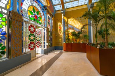 The polychrome glass of the Moorish greenhouse creates wonderful reflections and plays of light on the walls. Inside there are exotic and rare plants. Villa Torlonia park in Rome, Italy.