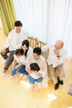 Odadaki kanepede oturan üç nesillik bir aile.