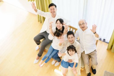 Odadaki kanepede oturan üç nesillik bir aile.