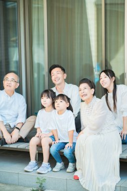 Üç kuşak aile güzel bir günde verandada dinleniyor.