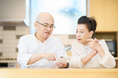 Üst düzey çift odada deneme yanılma yoluyla akıllı telefon kullanıyor.