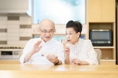 Üst düzey bir çift odada akıllı telefon kullanarak iletişim kuruyor.