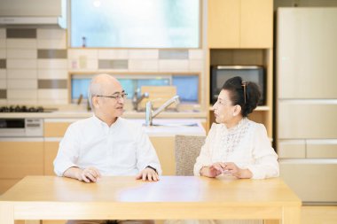 Üst düzey bir çift parlak bir oturma odasında sohbet ediyor.