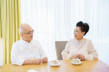 Üst düzey bir çift parlak bir oturma odasında sohbet ediyor.