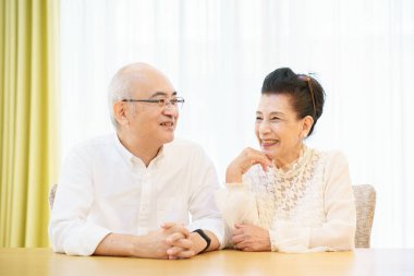 Yaşlı çift oturma odasında gülücükle sohbet ediyor.