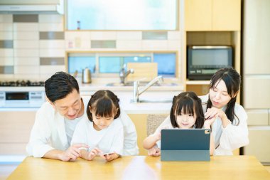 Odadaki tabletin ekranına bakan ebeveyn ve çocuk