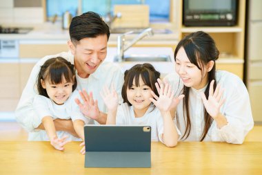 Odadaki tabletin ekranına bakan ebeveyn ve çocuk