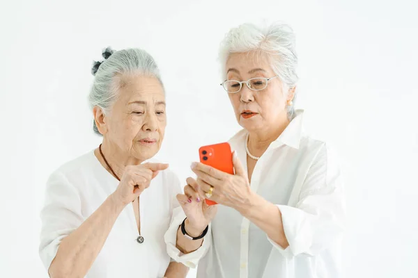 Senior women operating smartphone through trial and error