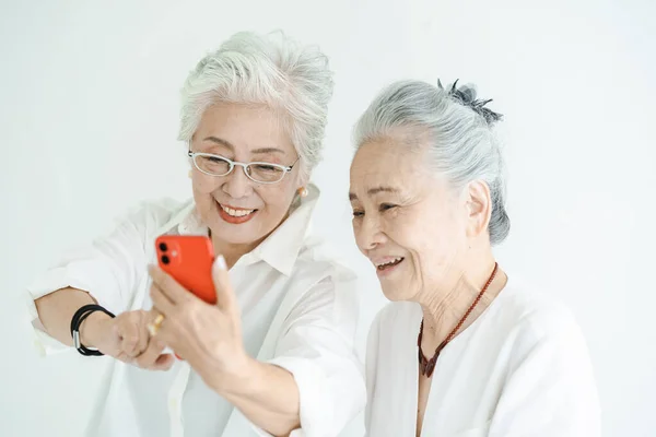 Seniorinnen Blicken Lächelnd Auf Smartphone Bildschirme — Stockfoto