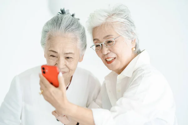 Seniorinnen Blicken Lächelnd Auf Smartphone Bildschirme — Stockfoto