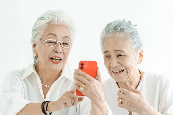 Seniorinnen Blicken Lächelnd Auf Smartphone Bildschirme — Stockfoto