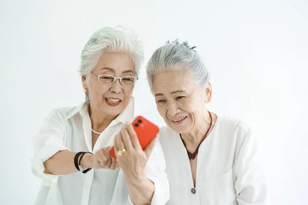 Senioren Die Met Een Glimlach Naar Smartphoneschermen Kijken — Stockfoto