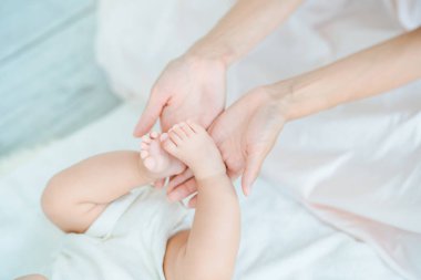 Annenin elleri odada bebeğin ayaklarını destekliyor.