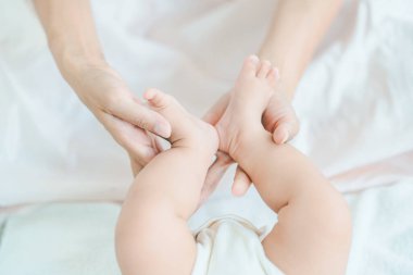 Annenin elleri odada bebeğin ayaklarını destekliyor.