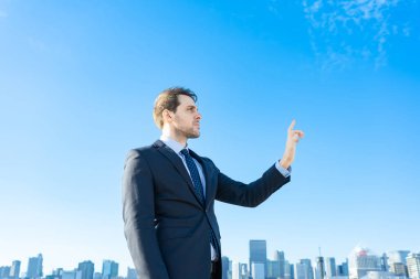 Elini ve şehir manzarasını tutan bir iş adamı