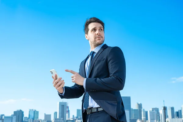 Een Zakenman Met Een Smartphone Blauwe Lucht — Stockfoto