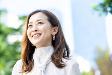 Güzel bir günde gülümseyen bir kadının açık hava portresi