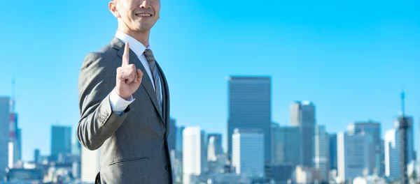 Ein Geschäftsmann Posiert Mit Erhobenem Zeigefinger Unter Blauem Himmel — Stockfoto