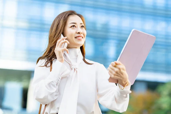 Een Glimlachende Vrouw Die Buiten Een Smartphone Praat — Stockfoto