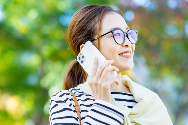 Açık Havada Akıllı Telefondan Konuşan Gülümseyen Bir Kadın — Stok fotoğraf