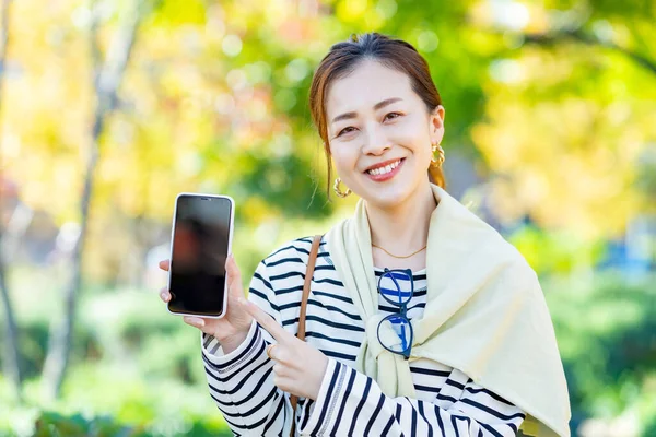 Una Mujer Sosteniendo Teléfono Inteligente Aire Libre — Foto de Stock