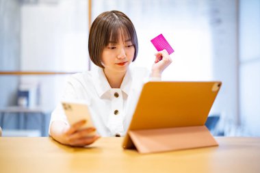 Çevrimiçi alışverişte kart ödemeleri yapan bir kadın 