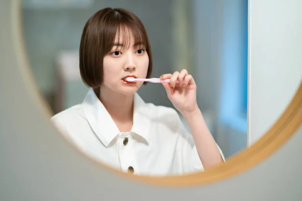 洗面所で歯を磨く若い女性 — ストック写真