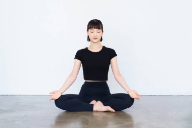 Asyalı genç kadın yoga pozunda mantra meditasyon yapıyor.
