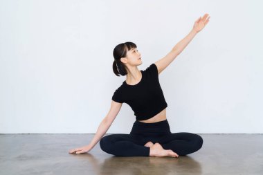 Yoga yapan ve evde esnek egzersiz yapan genç bir kadın.
