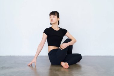 Oturan ve yoga yapan bir kadın.