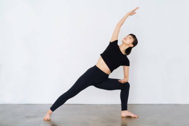 Yoga yapan genç bir kadın.)