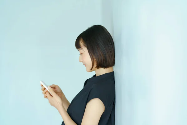 Ung Kvinna Som Håller Smartphone Inomhus — Stockfoto