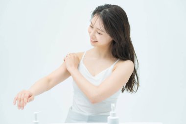 Teninin durumuna dokunup kontrol eden bir kadın. 