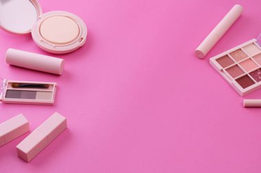 Makyaj aletleri ve pembe bir arka plan.