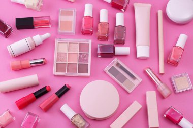 Pembe arkaplana yerleştirilmiş makyaj aletleri.
