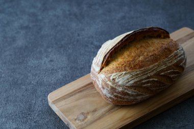 Ekmek ve kesim tahtası siyah bir masaya yerleştirildi