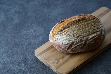 Ekmek ve kesim tahtası siyah bir masaya yerleştirildi