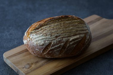 Ekmek ve kesim tahtası siyah bir masaya yerleştirildi