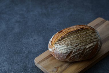 Ekmek ve kesim tahtası siyah bir masaya yerleştirildi