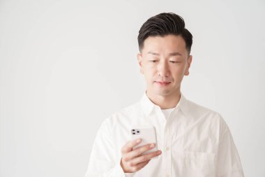 İçerideki akıllı telefon ekranına bakan bir adam.