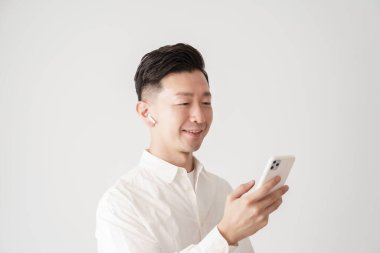 İçerideki akıllı telefon ekranına bakan bir adam.