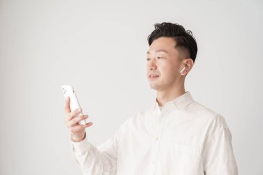 İçerideki akıllı telefon ekranına bakan bir adam.