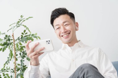 İçerideki akıllı telefon ekranına bakan bir adam.