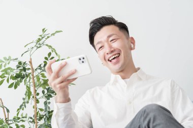 İçerideki akıllı telefon ekranına bakan bir adam.