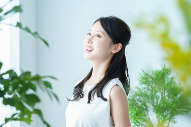 Pencerenin yanındaki ışıkta yıkanan bir kadın derin bir nefes alıyor.