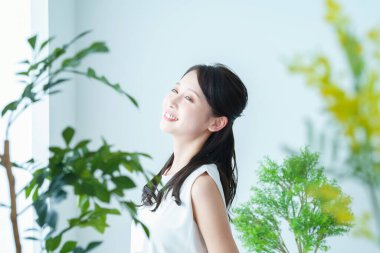 Pencerenin yanındaki ışıkta yıkanan bir kadın derin bir nefes alıyor.