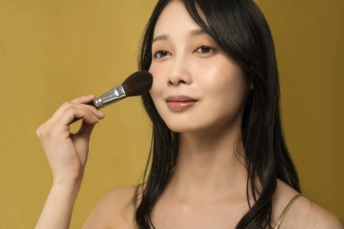 Parlak makyajlı ve altın sarısı olan bir kadın.