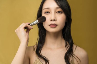 Parlak makyajlı ve altın sarısı olan bir kadın.